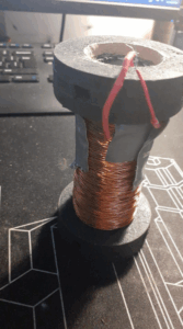 Final coil, with the coil holder made from a PVC pipe and the ends constructed from laser-cut wood, leaving three holes open to allow the threaded rod to hold the coil in place.